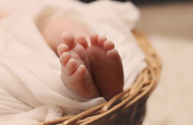 Petits pieds de bébé reposant dans un panier.